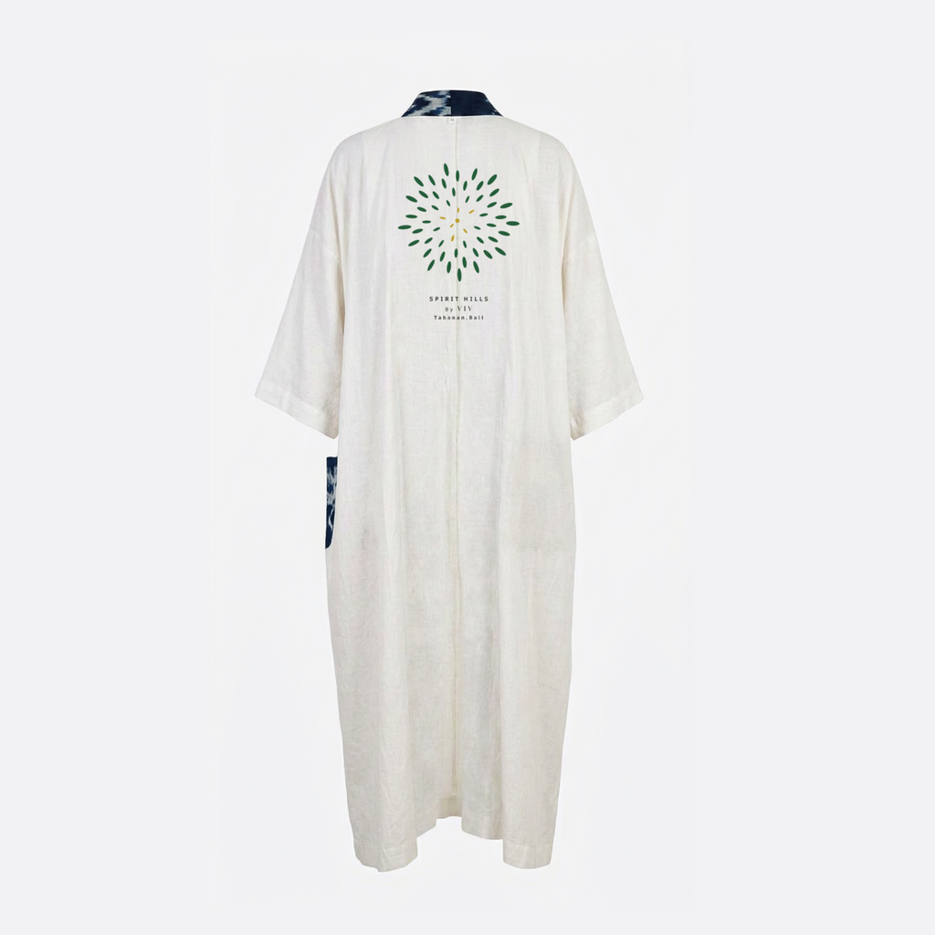 An off-white linen kimono robe shown from the back, featuring a green and yellow circular floral print with the text 'SPIRIT MALLA' and 'VENEZUELA' on the back, and dark blue patterned fabric accents at the collar and side.